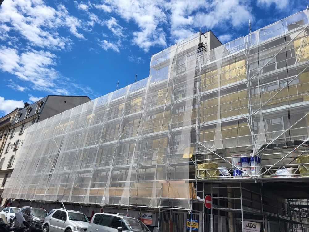 Ravalement de façade d’un immeuble sous échafaudage avec filet de protection, chantier SOGED