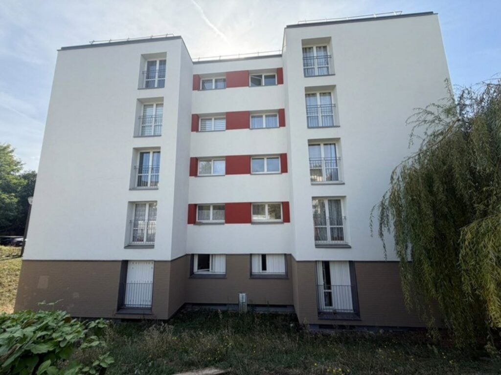 Façade ravalée avec bandeaux rouges d’un immeuble collectif à Ézanville, chantier SOGED